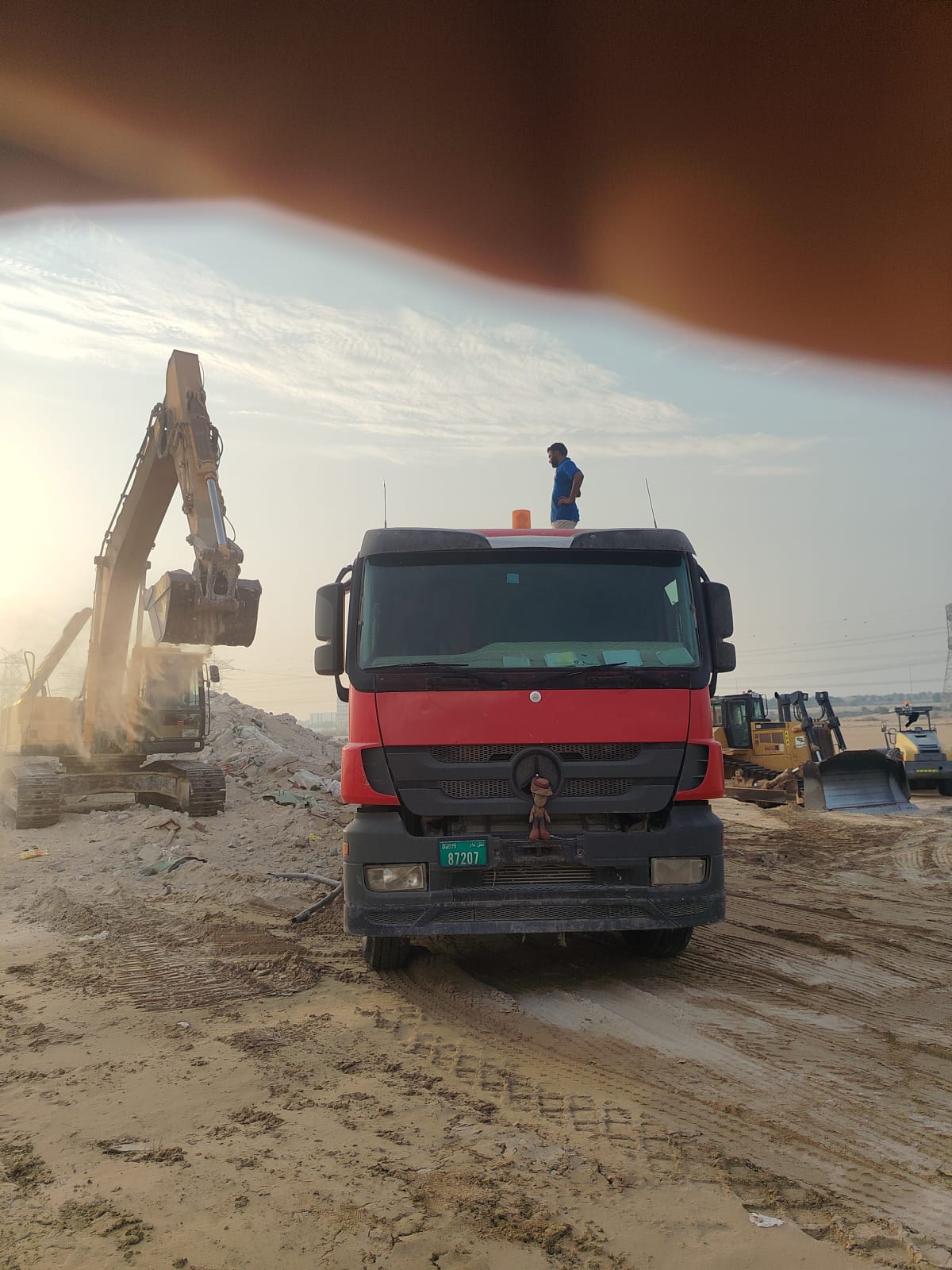 Dump truck and excavator working together on a construction waste shifting project In Al Rowaiyah Third - Dubai - United Arab Emirates